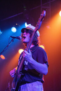 A picture of the guitarist of Sea Red play the guitar while singing Chez Maurice in St-Lazare